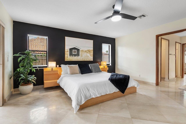 bedroom with baseboards, ceiling fan, and visible vents