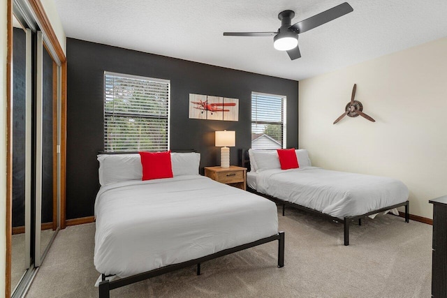 carpeted bedroom featuring baseboards and a ceiling fan