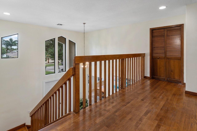 hallway with visible vents, recessed lighting, baseboards, and wood finished floors