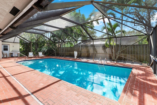 view of swimming pool featuring grilling area, a lanai, a patio area, a fenced in pool, and a fenced backyard