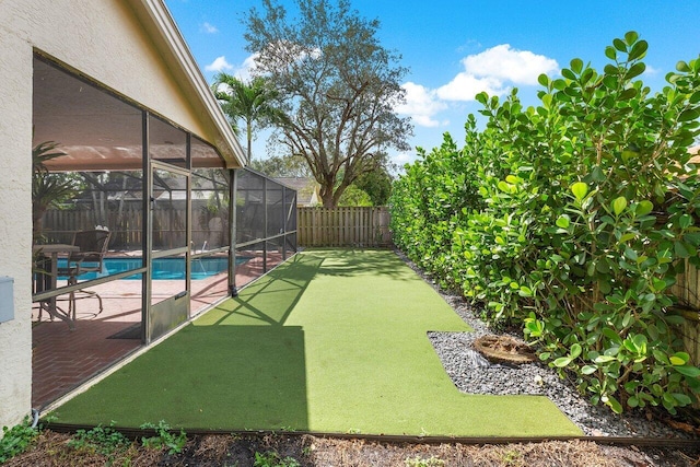 view of yard featuring glass enclosure, a patio, a fenced in pool, and a fenced backyard