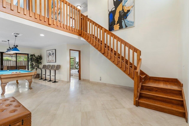 stairs with billiards, a towering ceiling, visible vents, baseboards, and recessed lighting