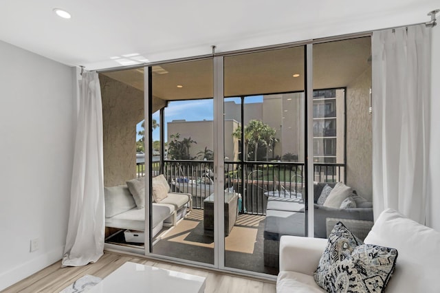 doorway to outside featuring wood finished floors and floor to ceiling windows
