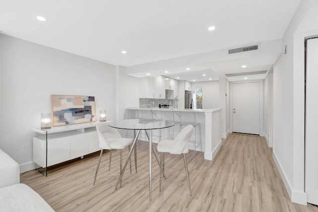 dining space featuring baseboards, recessed lighting, visible vents, and light wood-style flooring
