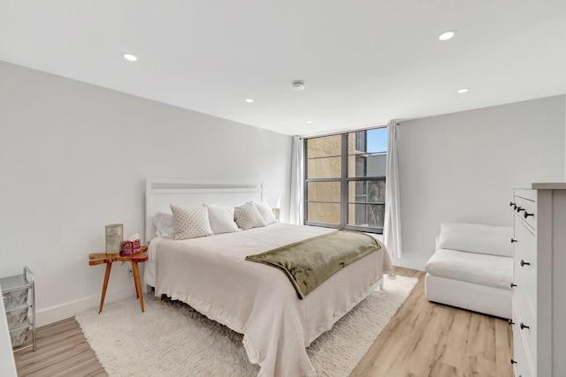 bedroom with recessed lighting, light wood finished floors, and baseboards