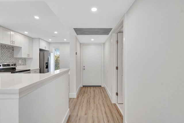 hall with recessed lighting, light wood-style flooring, and baseboards