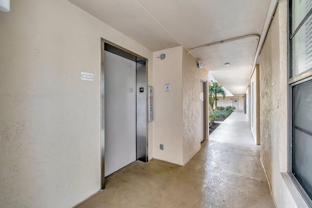 hallway featuring concrete floors and elevator