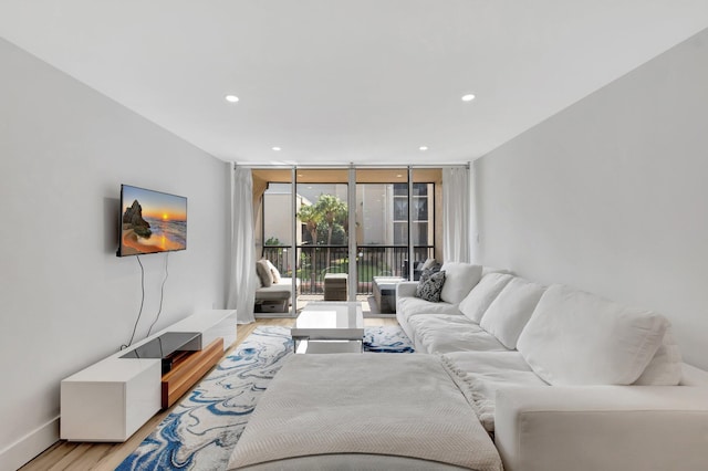 living area featuring recessed lighting, expansive windows, light wood finished floors, and baseboards
