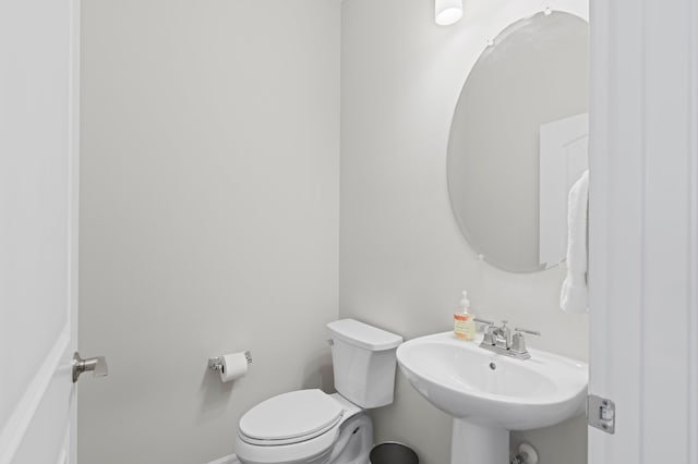 half bathroom featuring a sink and toilet