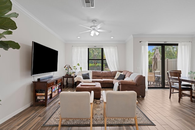 living area featuring wood finished floors, ceiling fan, baseboards, recessed lighting, and crown molding