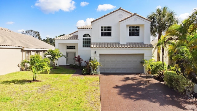 mediterranean / spanish house with a tile roof, decorative driveway, a front lawn, a garage, and stucco siding