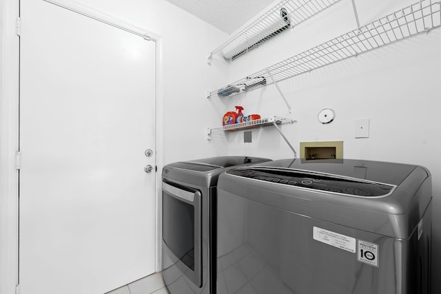 laundry area with light tile patterned flooring, independent washer and dryer, and laundry area