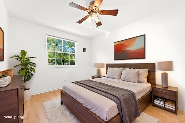 bedroom featuring light wood-type flooring, a ceiling fan, and baseboards