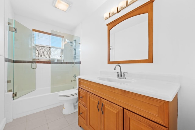 full bath featuring combined bath / shower with glass door, vanity, tile patterned flooring, and toilet
