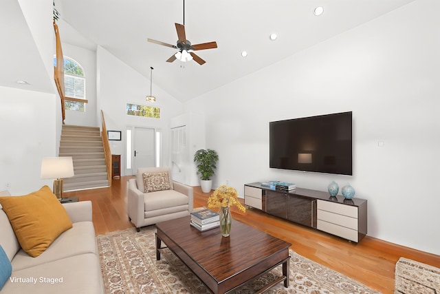 living room with stairway, high vaulted ceiling, a ceiling fan, wood finished floors, and recessed lighting