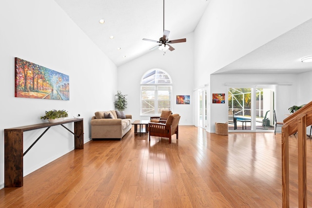 living area featuring ceiling fan, recessed lighting, a towering ceiling, and light wood-type flooring