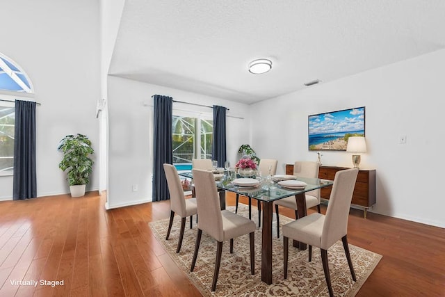 dining room featuring baseboards, wood finished floors, and visible vents