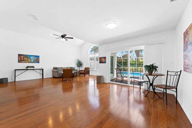 living area with lofted ceiling, wood finished floors, and ceiling fan