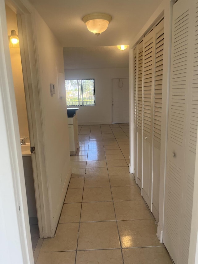 1626 Meadows Cir W Unit 1626, Boynton Beach, FL 33436 - hallway with baseboards and light tile patterned floors