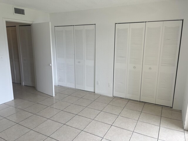 1626 Meadows Cir W Unit 1626, Boynton Beach, FL 33436 - unfurnished bedroom featuring light tile patterned floors, two closets, and visible vents
