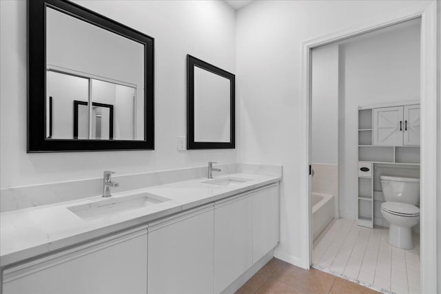 full bathroom featuring tile patterned floors, a sink, double vanity, and toilet