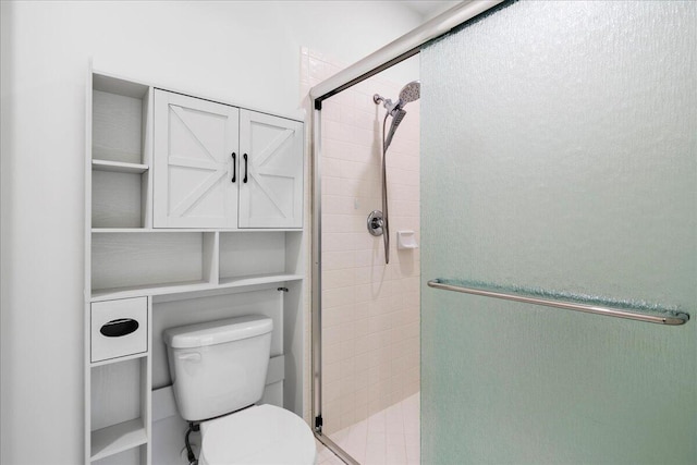bathroom with a shower stall and toilet