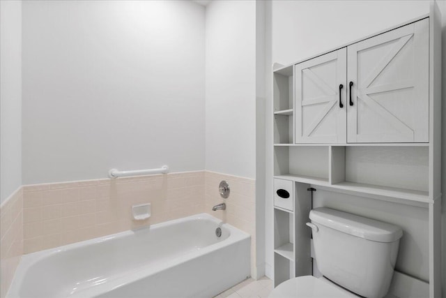 bathroom featuring toilet, tile patterned flooring, and a garden tub