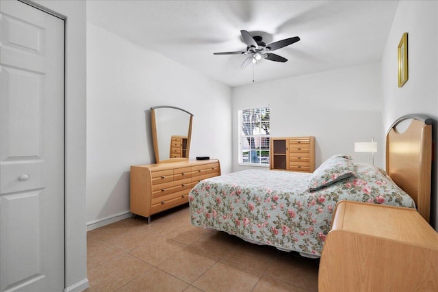bedroom featuring a ceiling fan, baseboards, and light tile patterned flooring
