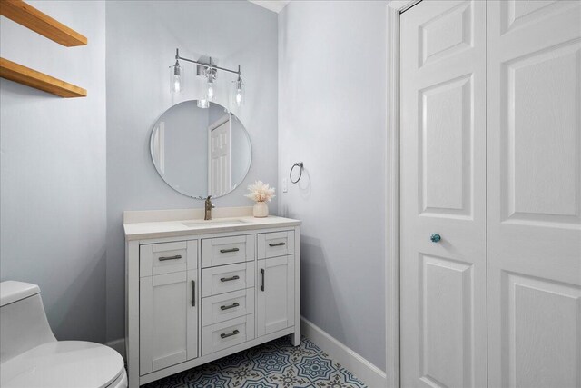bathroom with vanity, toilet, and baseboards