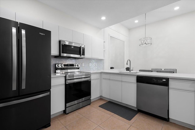kitchen with light countertops, appliances with stainless steel finishes, open shelves, and a sink