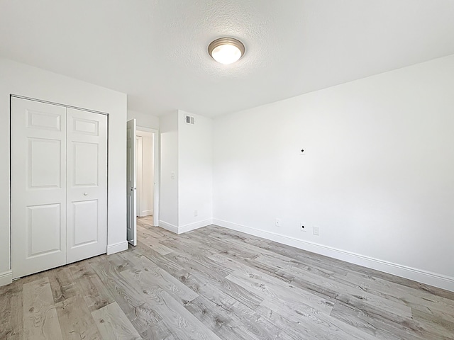 595 Vista Isles Dr Unit 1926, Sunrise, FL 33325 - unfurnished bedroom featuring light wood-type flooring, baseboards, a closet, and a textured ceiling
