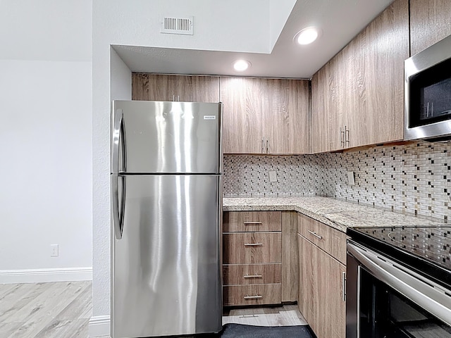 595 Vista Isles Dr Unit 1926, Sunrise, FL 33325 - kitchen with stainless steel appliances, tasteful backsplash, baseboards, light stone counters, and light wood-style flooring