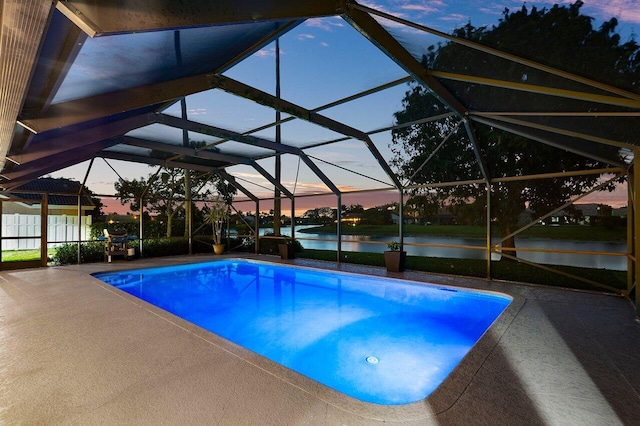 11217 Island Lakes Ln, Boca Raton, FL 33498 - pool at dusk featuring a water view, an outdoor pool, and a patio