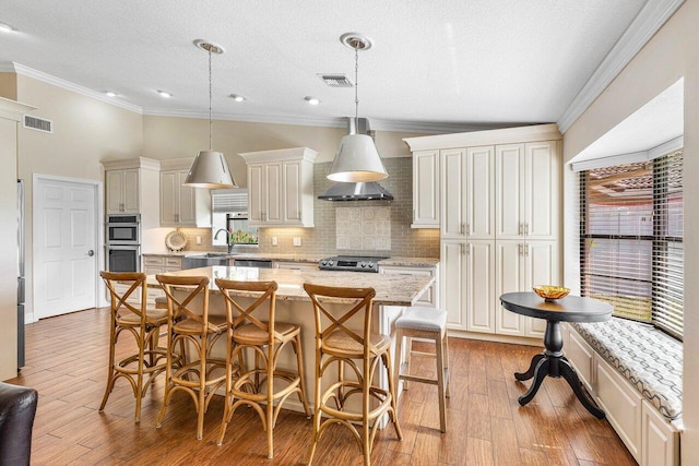 11217 Island Lakes Ln, Boca Raton, FL 33498 - kitchen featuring appliances with stainless steel finishes, tasteful backsplash, crown molding, a breakfast bar, and a center island