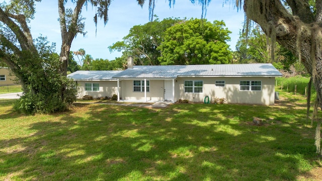 2675 SW 24th Ave, Okeechobee, FL 34974 - ranch-style home with a front lawn, stucco siding, metal roof, and a chimney
