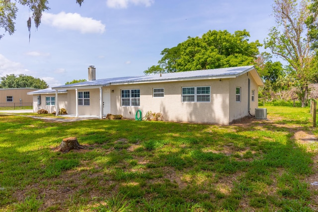 2675 SW 24th Ave, Okeechobee, FL 34974 - rear view of property with a lawn, stucco siding, central air condition unit, and metal roof