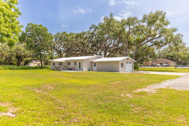 2675 SW 24th Ave, Okeechobee, FL 34974 - view of front of house with concrete driveway, a front lawn, a garage, and a chimney
