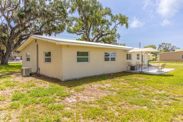 2675 SW 24th Ave, Okeechobee, FL 34974 - rear view of house with stucco siding, a patio area, central air condition unit, and metal roof