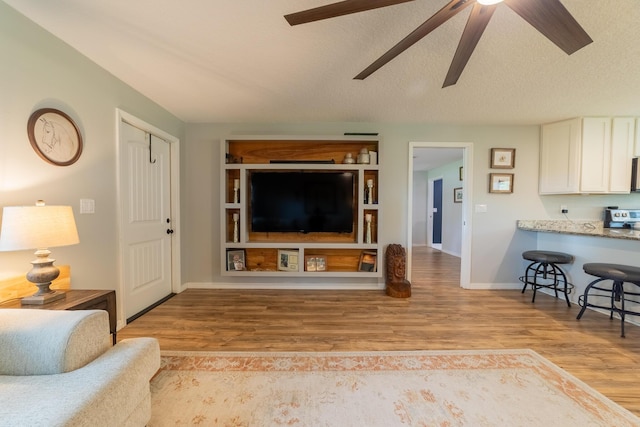 2675 SW 24th Ave, Okeechobee, FL 34974 - living area with wood finished floors, ceiling fan, baseboards, and a textured ceiling