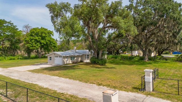 2675 SW 24th Ave, Okeechobee, FL 34974 - view of front of home featuring driveway, an attached garage, and view of wooded area