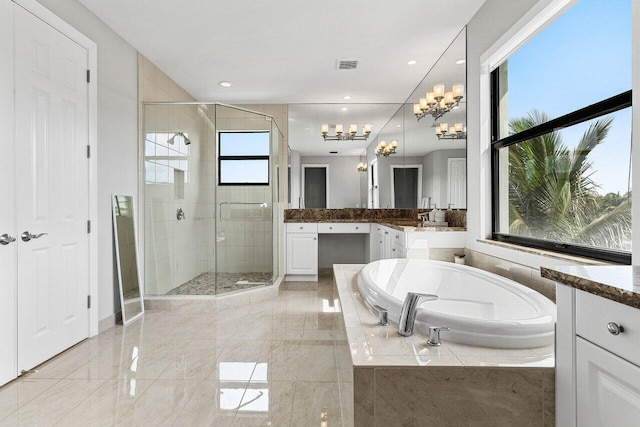 bathroom featuring an inviting chandelier, vanity, visible vents, a bath, and a shower stall