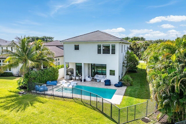 back of property with stucco siding, a fenced backyard, a fenced in pool, a patio area, and a lawn