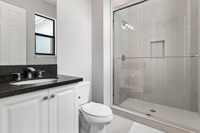 bathroom with vanity, toilet, and a stall shower