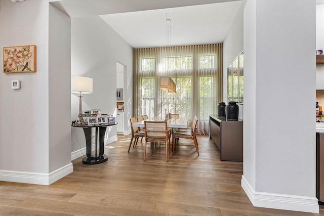 dining space with baseboards and wood finished floors