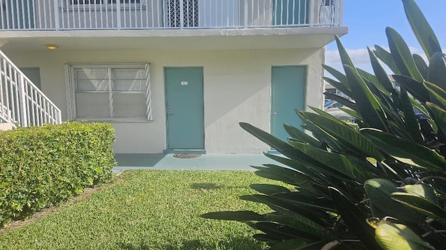 880 Horizons W Unit 112, Boynton Beach, FL 33435 - view of exterior entry featuring stucco siding and a balcony