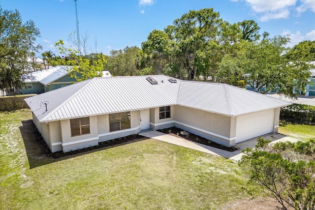 rear view of house featuring a lawn, an attached garage, and stucco siding