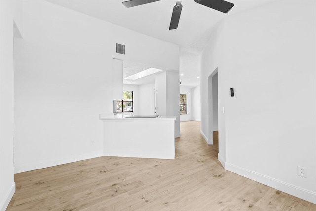 unfurnished living room with baseboards, visible vents, light wood-style floors, and ceiling fan