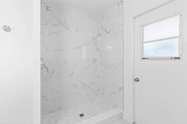 full bathroom with a marble finish shower