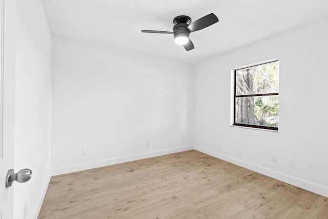 empty room featuring wood finished floors, a ceiling fan, and baseboards