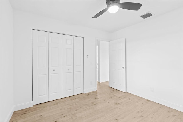 unfurnished bedroom with wood finished floors, visible vents, a ceiling fan, a closet, and baseboards